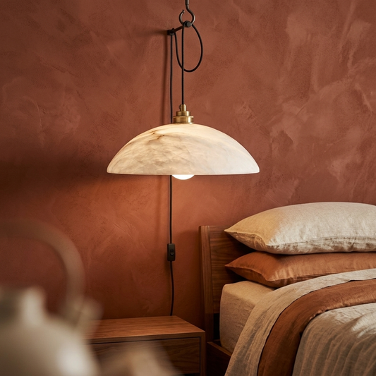 Alabaster dome swag pendant beside a bed