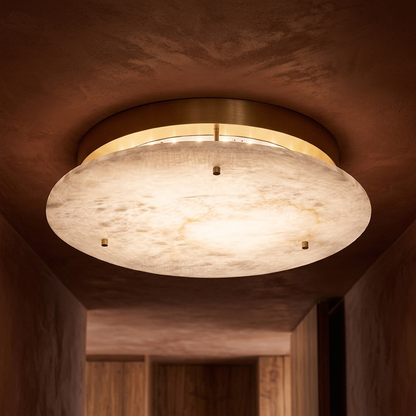 Alabaster disc flush-mount ceiling light in a warm hallway